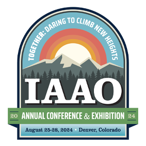 Logo is an illustration of a mountain with a sunrise behind it and a forest in front of it. Text reads: "Together: Daring to Climb New Heights. IAAO Annual Conference & Exhibition 2024. August 25-28, 2024. Denver, Colorado."